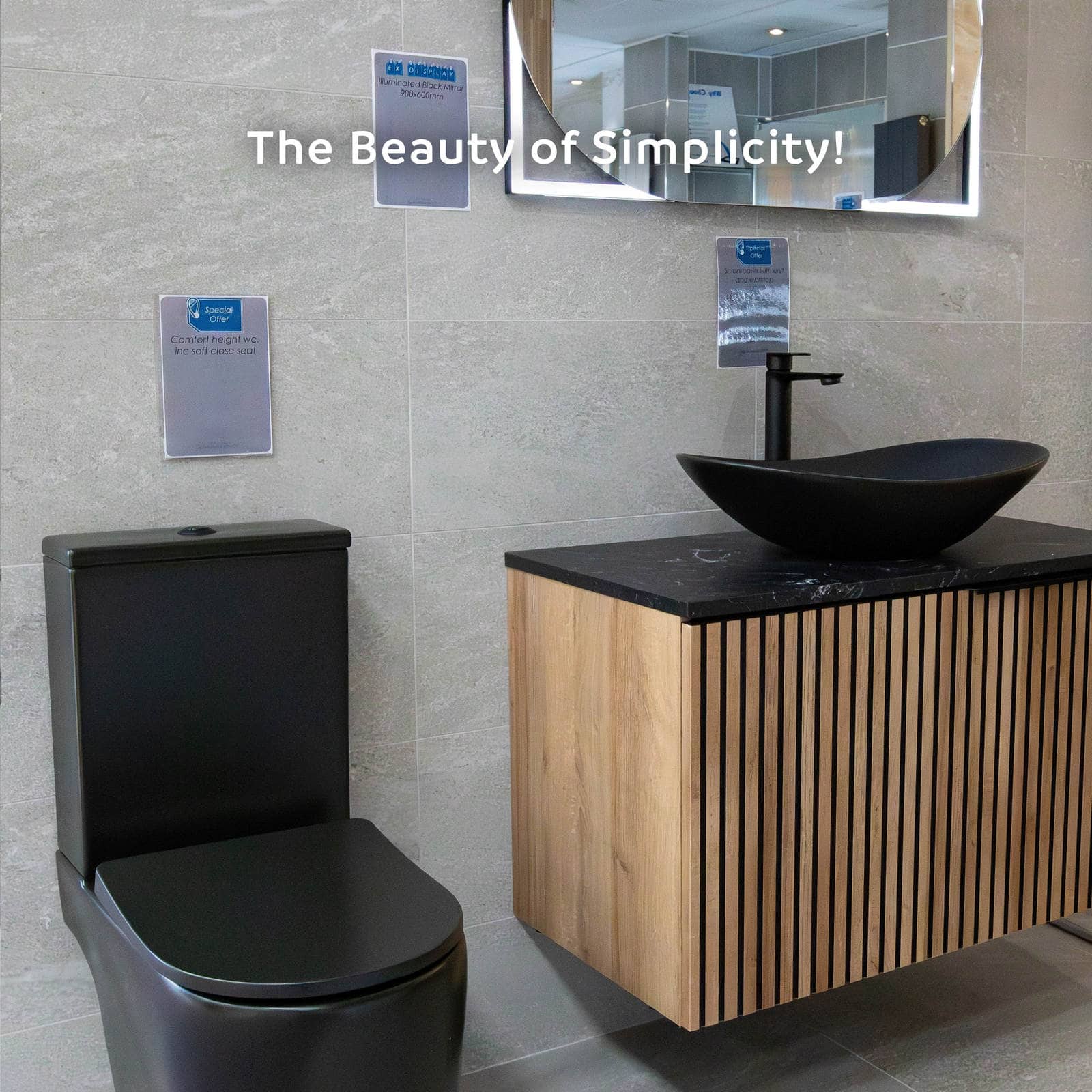 A wall-hung ribbed oak vanity with a black stone top, black oval countertop basin and matt black tap, beside a black WC, captioned The Beauty of Simplicity