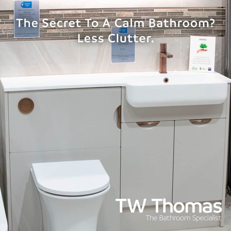 A white fitted WC unit and basin run with brushed copper handles and tap against stone-effect tiles, captioned The Secret To A Calm Bathroom? Less Clutter