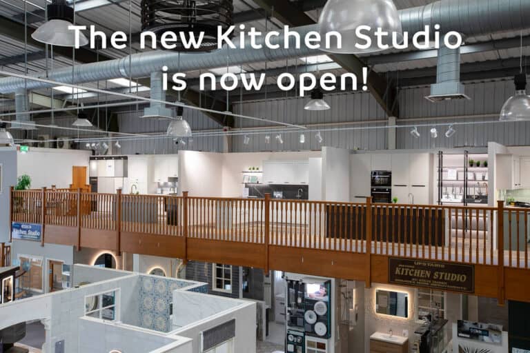 The showroom mezzanine seen from the balcony, kitchen displays above and bathroom displays below, captioned The new Kitchen Studio is now open
