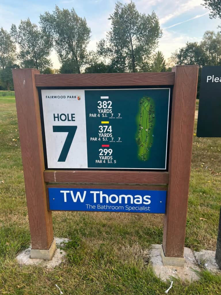 The hole 7 tee marker at Fairwood Park Golf Club showing the yardages, with a TW Thomas sponsor board beneath it