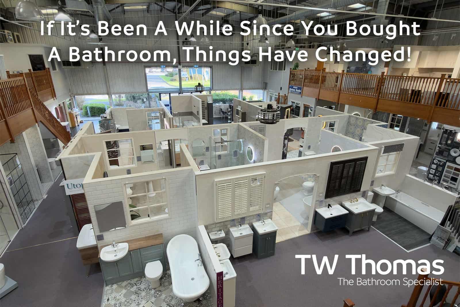 The TW Thomas showroom seen from the mezzanine with room-set displays laid out below, captioned If It's Been A While Since You Bought A Bathroom, Things Have Changed
