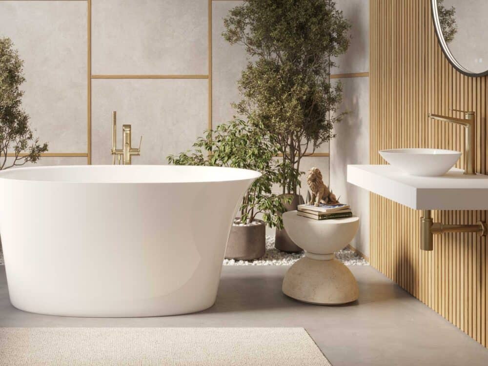 Adamsez curved freestanding bath beside a window with planting and a wall-hung basin shelf