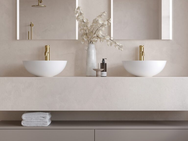 A pair of Adamsez Orb AdCast Stone countertop basins on a stone vanity with brushed brass wall taps