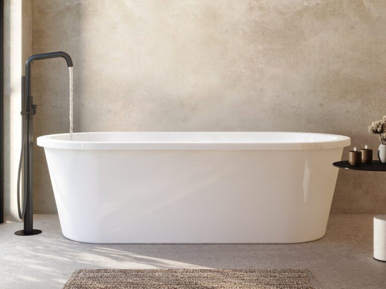 Adamsez oval freestanding bath with a matt black floor-standing mixer against a warm plaster wall