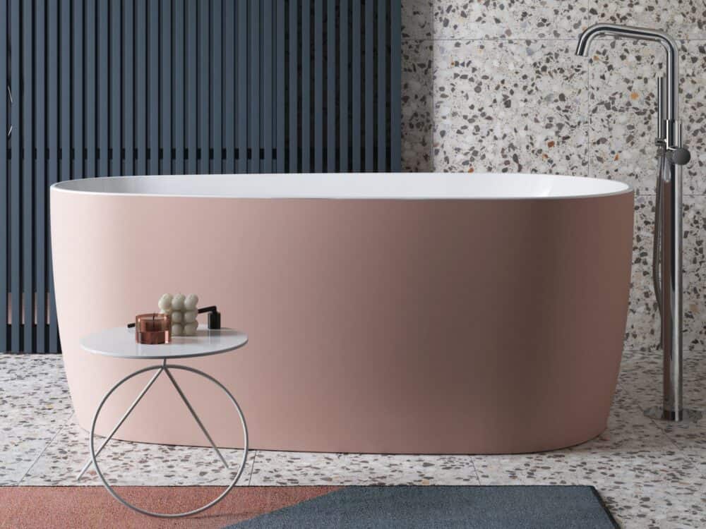 Adamsez freestanding bath finished in dusky pink AdColour against a blue fluted wall with a terrazzo floor