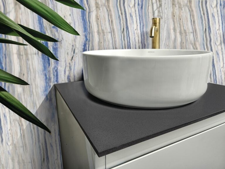 Armera round ceramic countertop basin on a pebble grey slab above a wall-hung unit