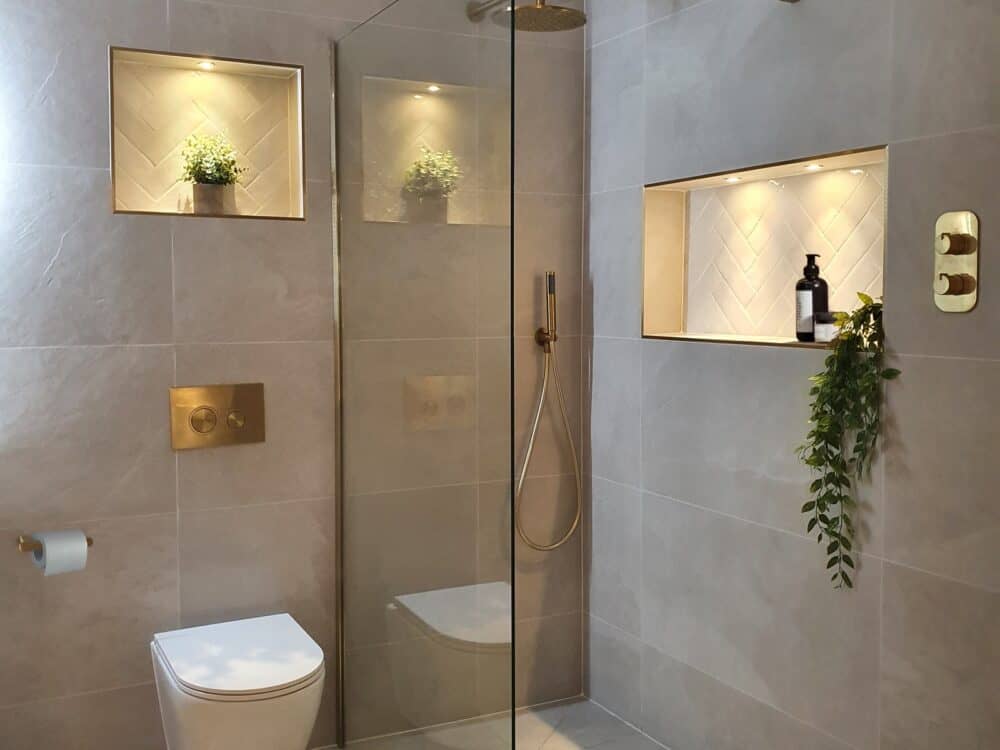 Armera concealed shower valve, handset and flush plate in brushed gold in a walk-in shower room