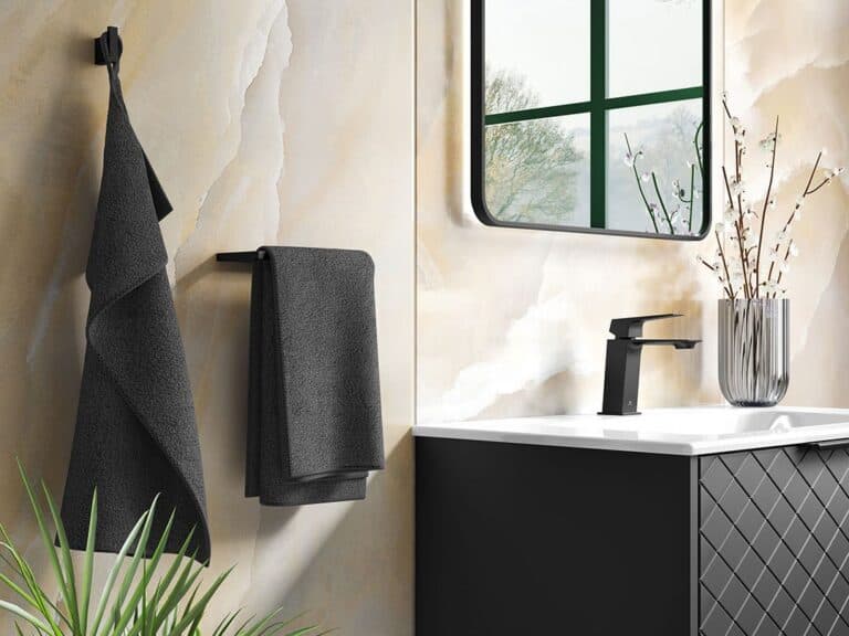 Black towel hook and towel bar beside a basin and mirror