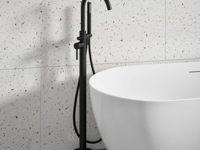 Black floor-standing bath shower mixer beside a freestanding bath