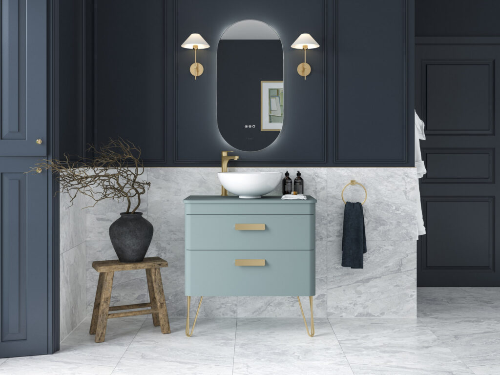 Veldeau Henbury pale blue vanity unit on brass legs with an oval illuminated mirror against navy panelling