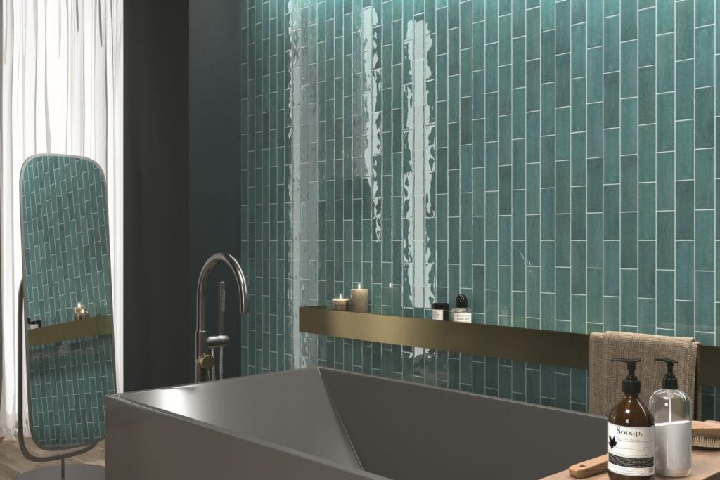 A teal gloss tiled wall beside a dark freestanding bath