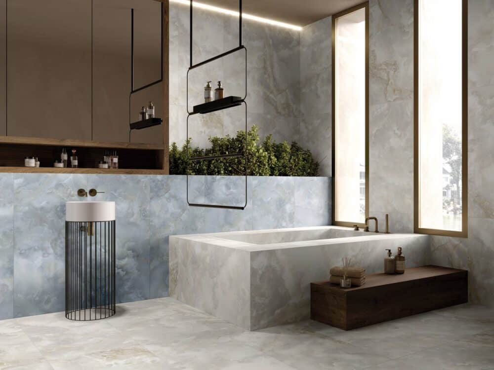 A grey stone effect tiled bathroom with a bath and vanity unit
