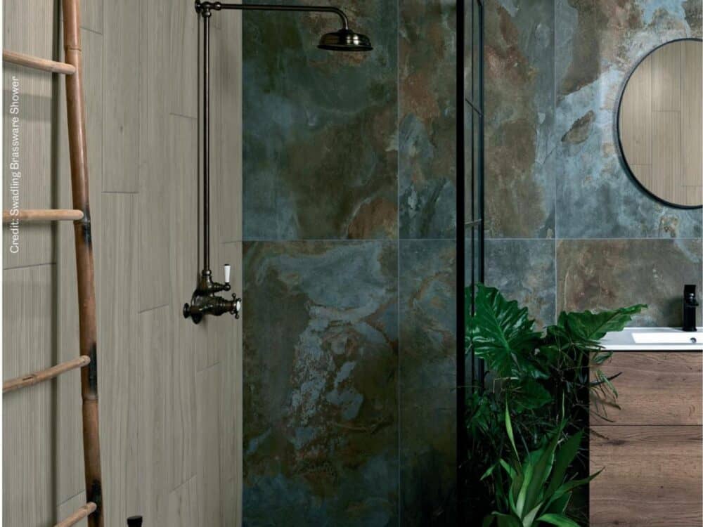 A teal textured porcelain shower wall with a timber vanity