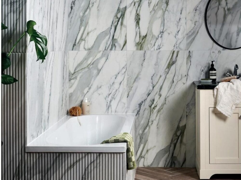 A marble effect porcelain wall behind a panelled bath