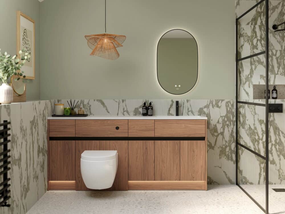 Calypso Bowland fitted furniture in weathered oak with a wall-hung WC, backlit oval mirror and rattan pendant against a sage wall
