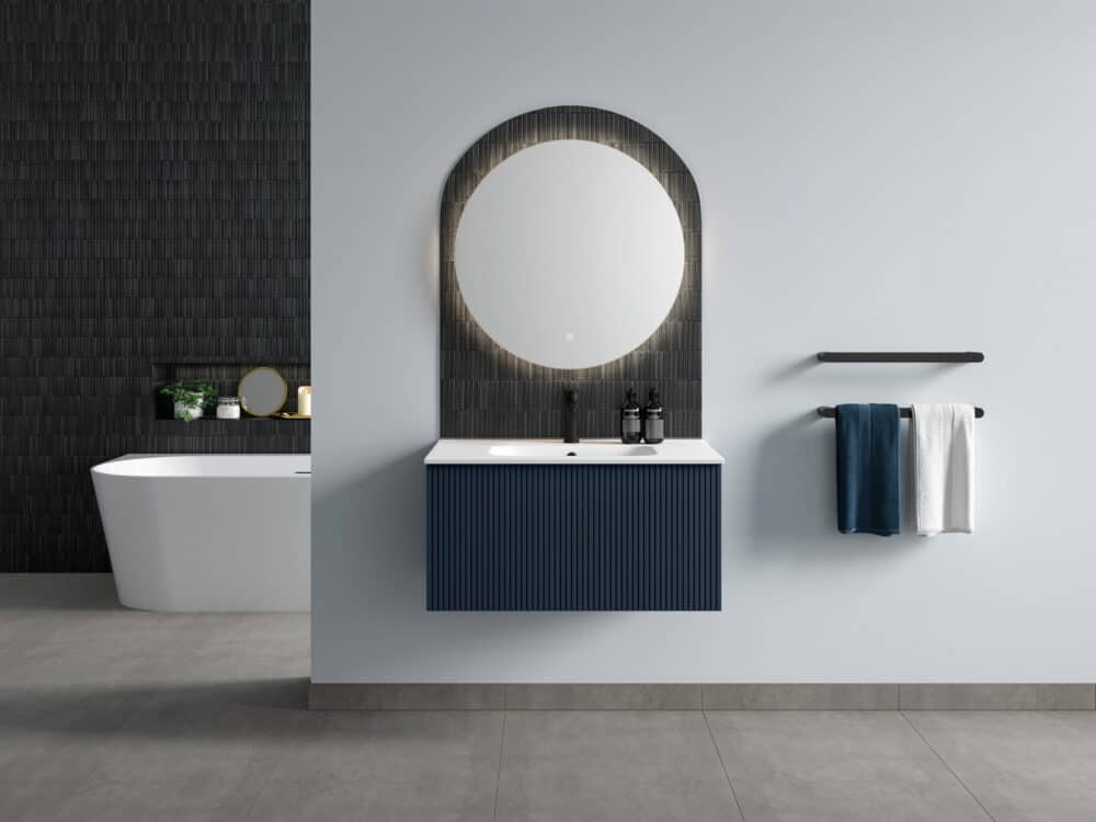 Calypso Minori fluted wall-hung vanity in admiral blue with a round mirror in an arched recess