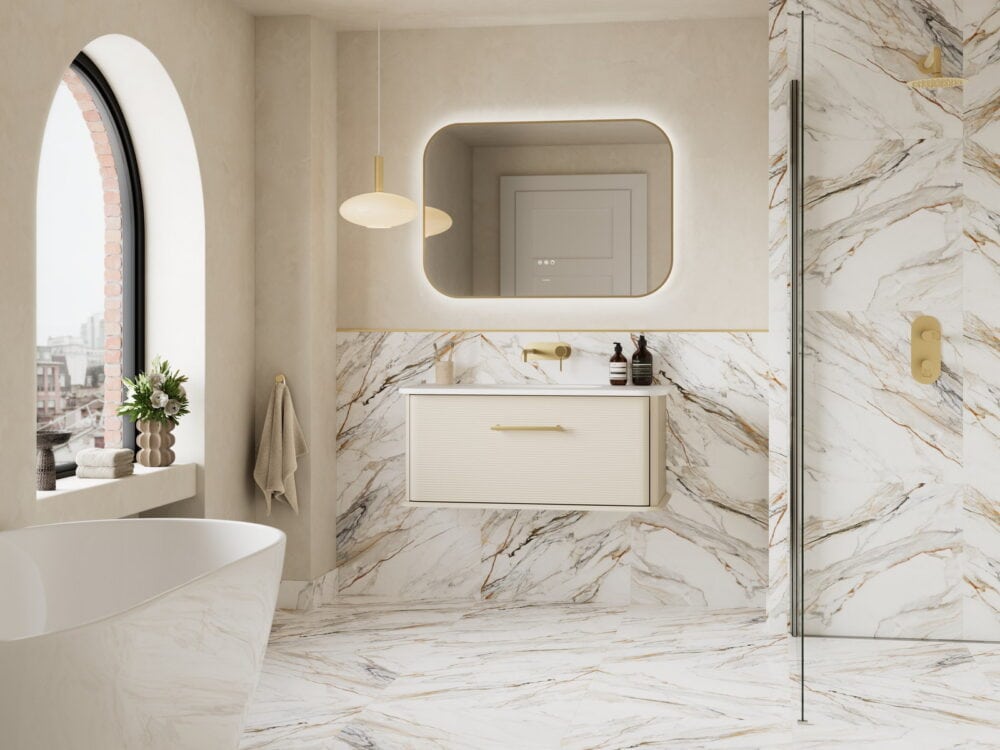 Calypso Petra wall-hung vanity in soft linen with a backlit mirror against Calacatta marble and an arched window