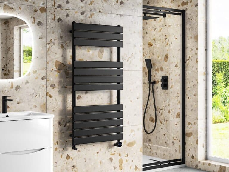 Black flat-panel heated towel rail on a terrazzo-effect wall