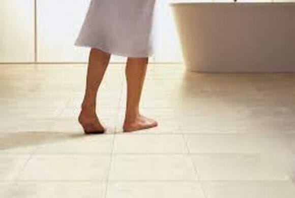 person walking over tiled underfloor heating area in bathroom