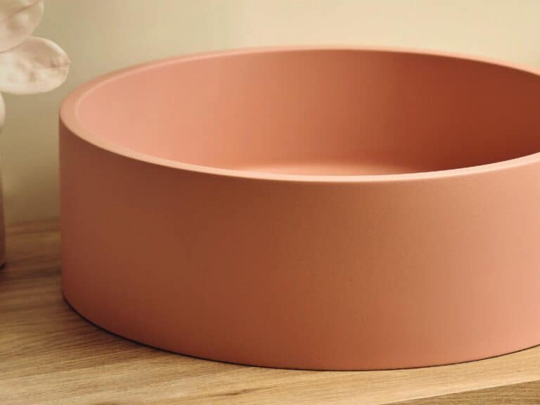 HiB Entero round concrete vessel basin in a soft terracotta finish on a timber countertop