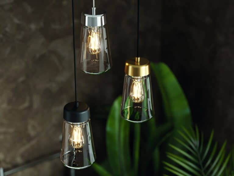 Three HiB Summit glass pendant lights with exposed filament bulbs against a dark wall