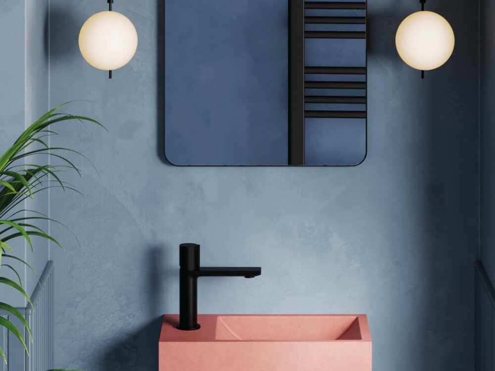 HiB Entero rectangular concrete basin in pink on a deep blue wall with globe wall lights