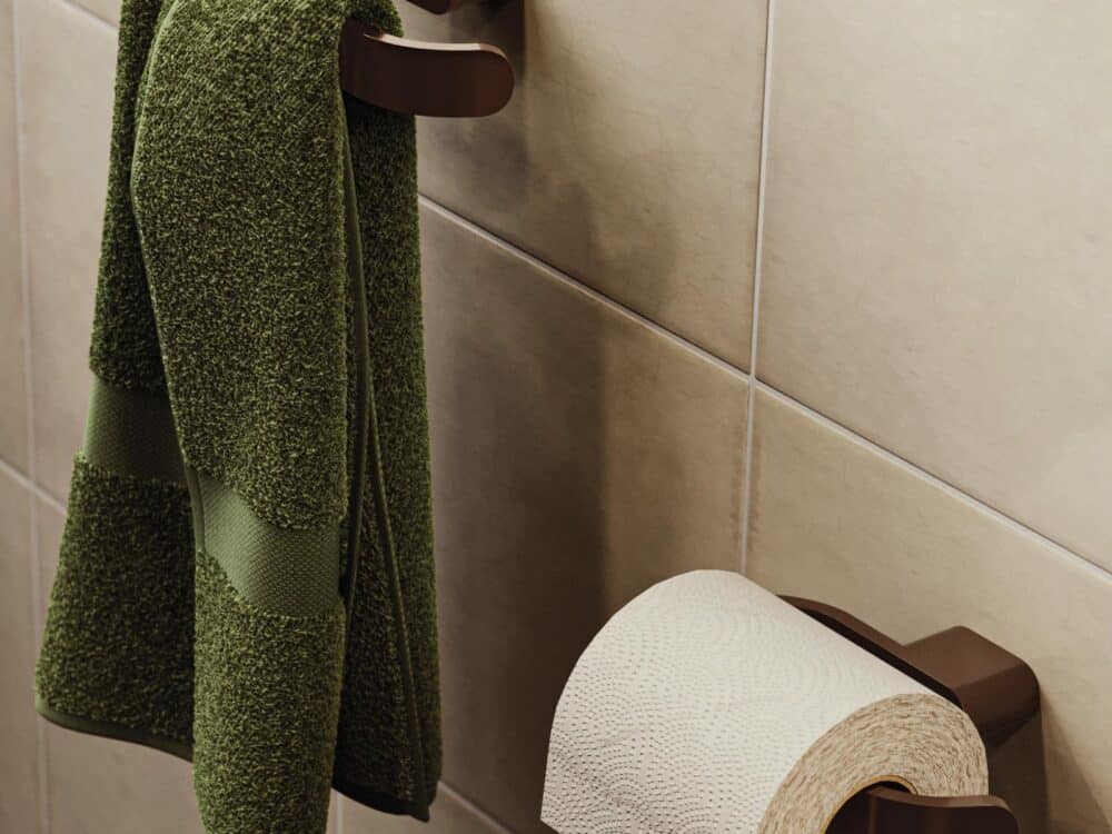 HiB Pico toilet roll holder and towel rail in brushed bronze with a green towel