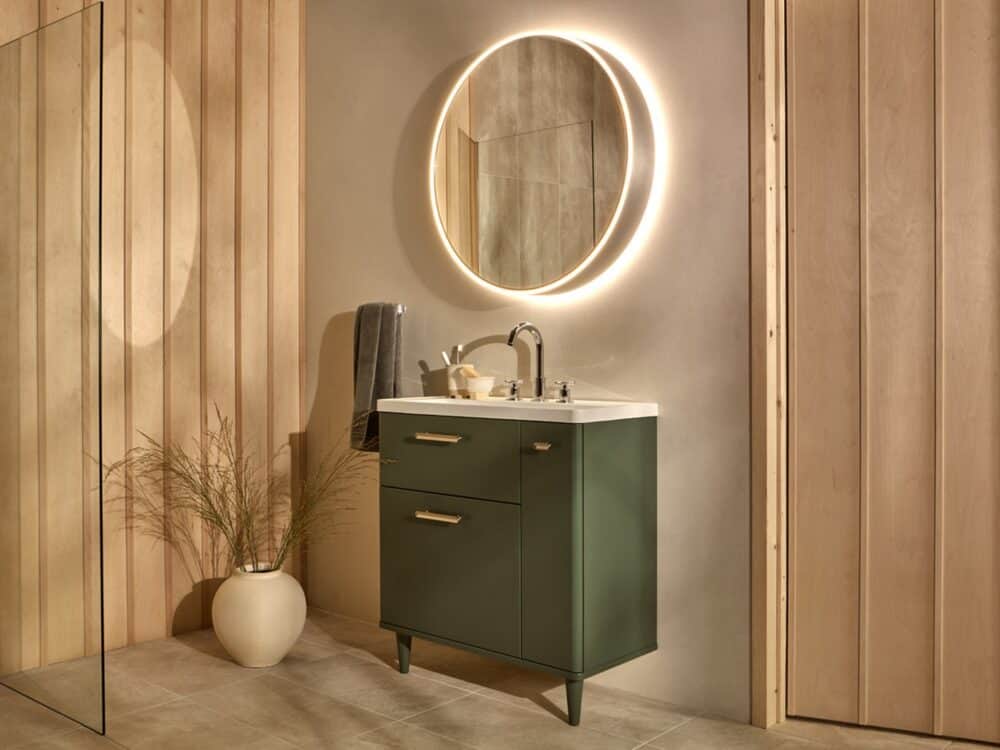 hib.inspire Auryn 80 circular LED mirror cabinet in brushed aluminium above a green floor-standing basin unit