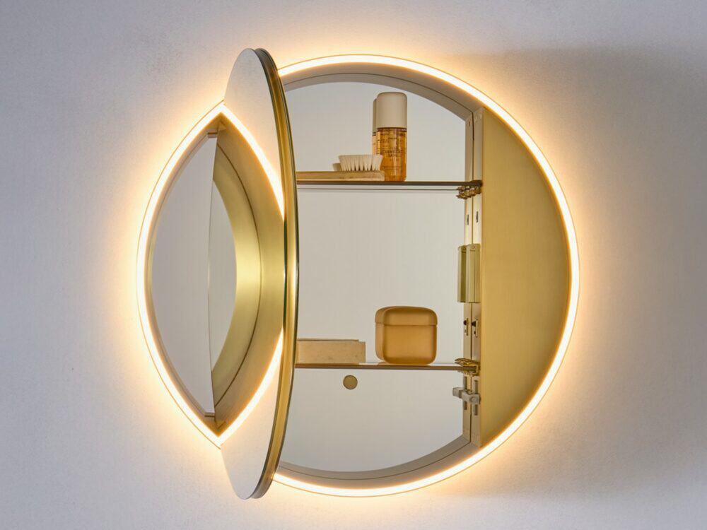 hib.inspire Auryn circular LED mirror cabinet in brushed brass with its door open, showing the lit glass shelves