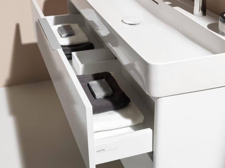 Laufen VAL double washbasin on a white fitted vanity unit with the drawer open on folded towels