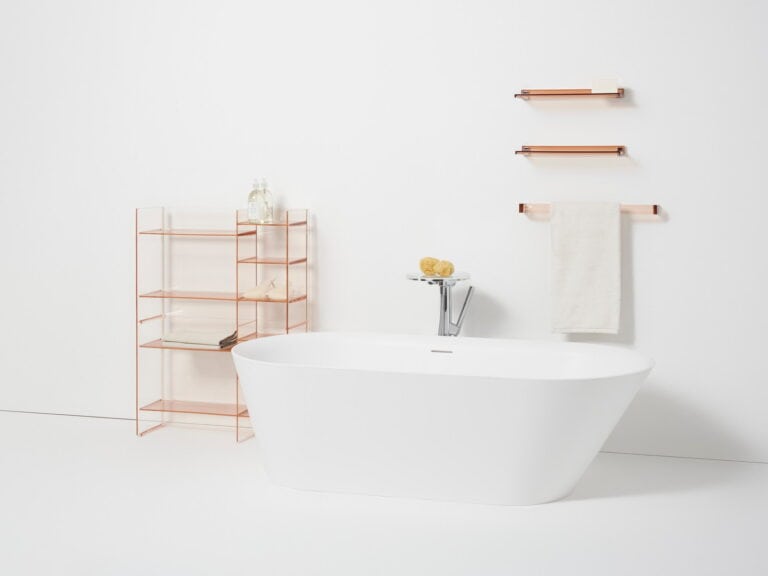 Kartell by Laufen white freestanding bath with a floor-standing chrome mixer and copper shelving