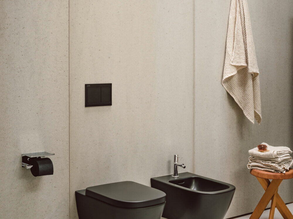 Laufen MEDA WC and bidet in matt brown against a pale stone wall