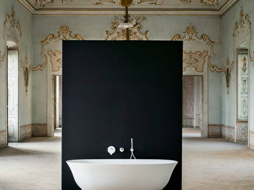 Laufen The New Classic freestanding bath against a black panel in a frescoed palazzo room