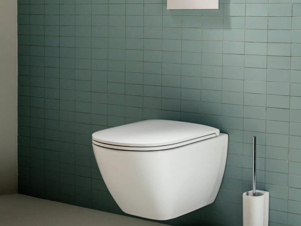 Laufen LUA wall-hung WC and white flush plate against green mosaic tiles