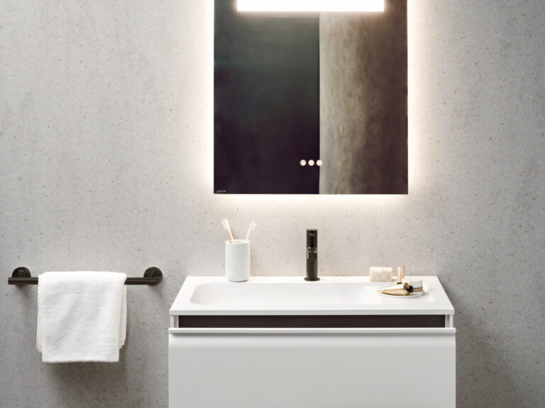 Laufen MEDA backlit rectangular mirror above a white vanity unit against a concrete wall