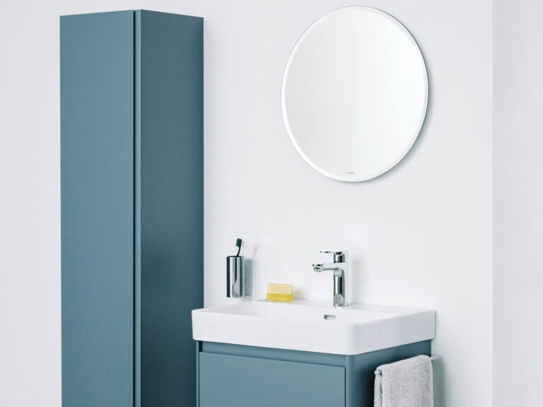 Laufen Base 2.0 teal wall-hung vanity unit and tall cabinet with a round mirror