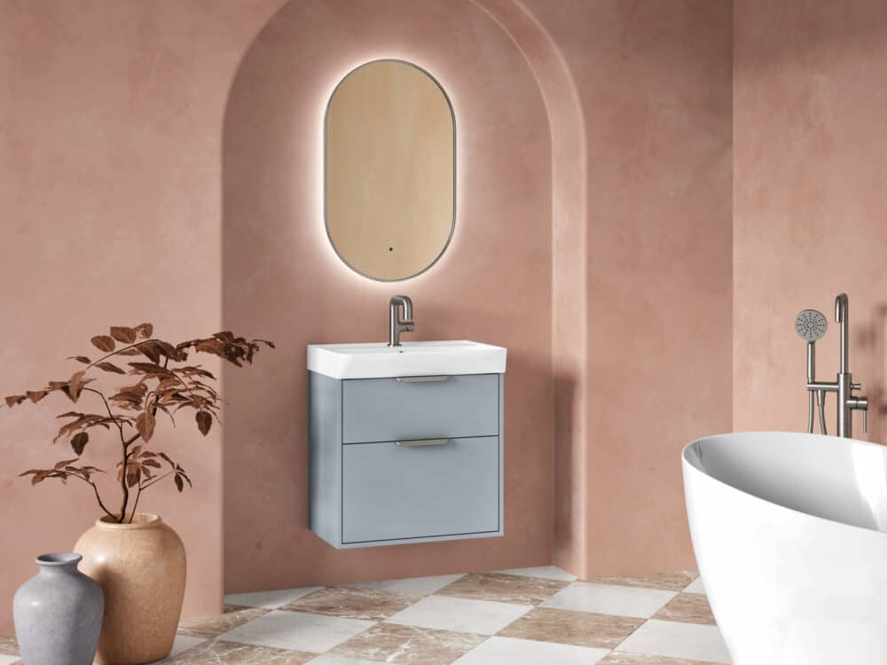MyLife Calia light blue wall-hung vanity in a terracotta arched alcove with an illuminated oval mirror