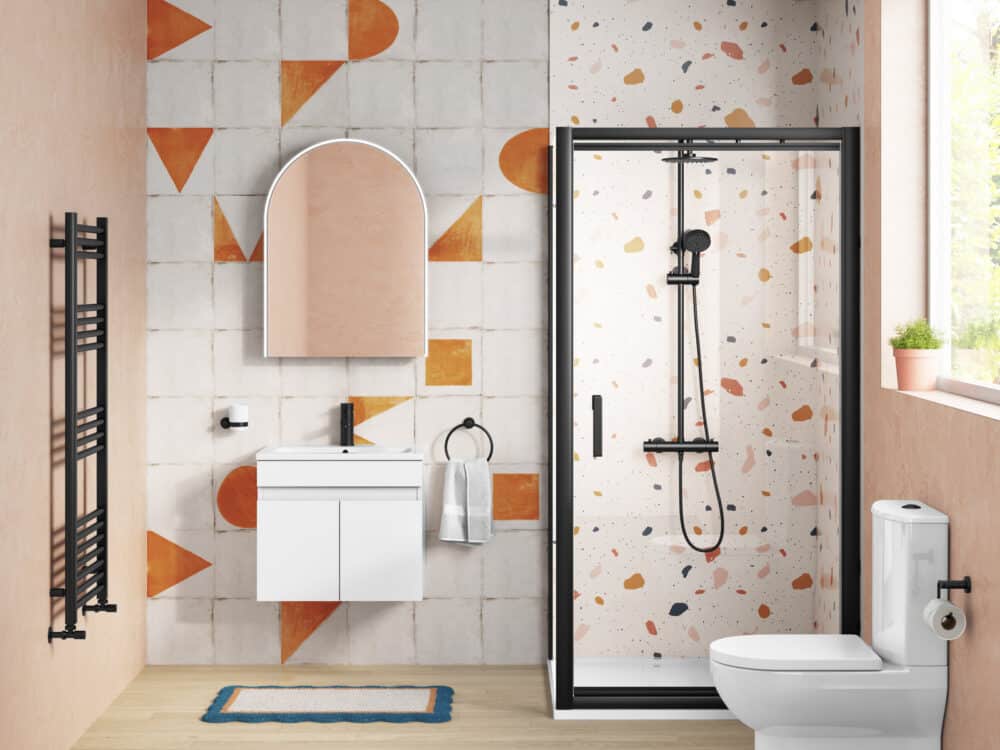 MyStyle bathroom with a black-framed shower enclosure, arched mirror, white vanity and close-coupled WC against patterned tiling