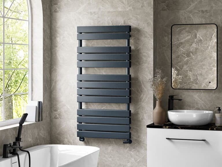 MyLife Jett heated towel rail in anthracite beside a freestanding bath