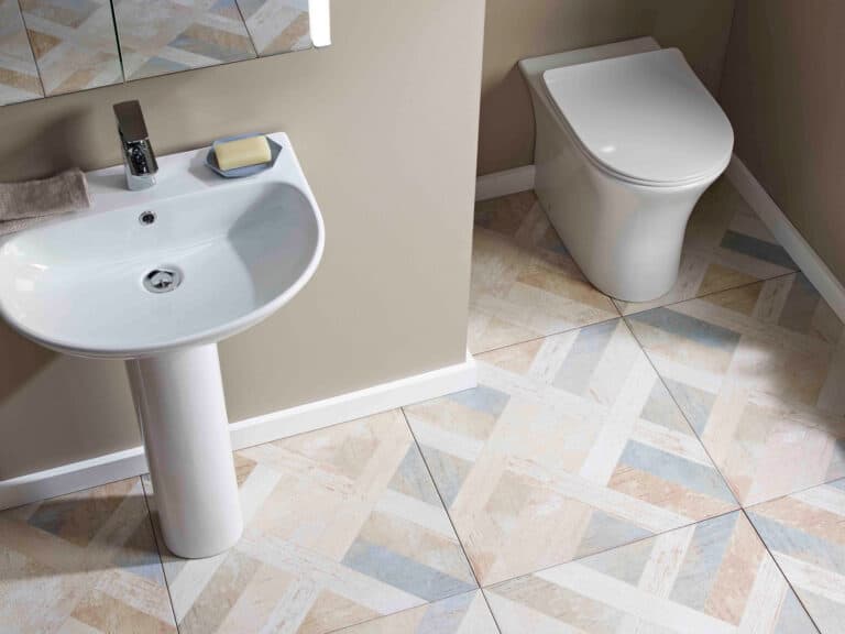 An R2 Radar bathroom suite - basin, pedestal and back-to-wall WC together on a patterned tiled floor