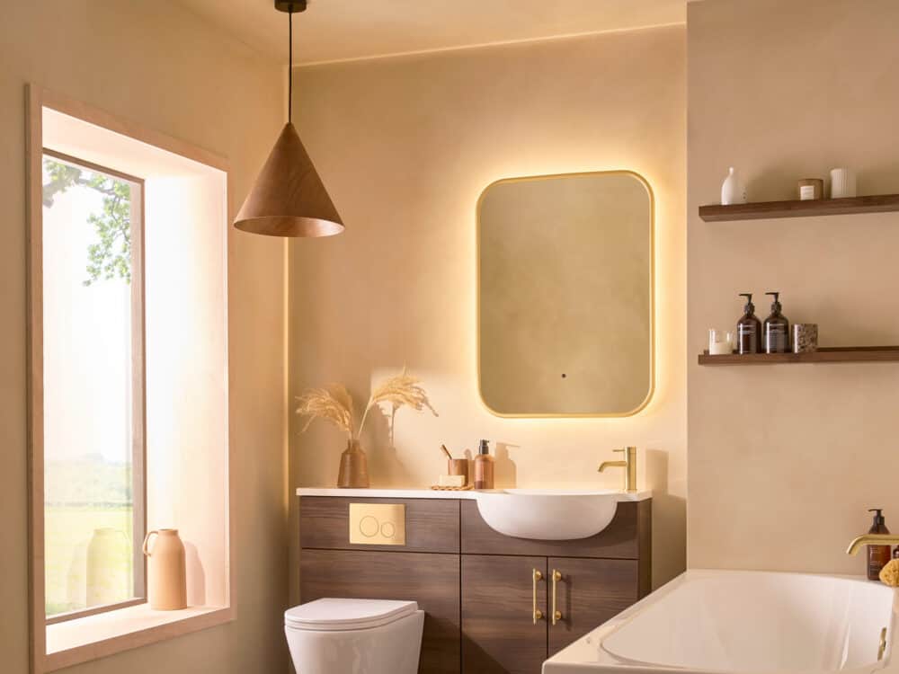An R2 Muse fitted furniture run in Calabrian walnut with an illuminated mirror and a bath beyond
