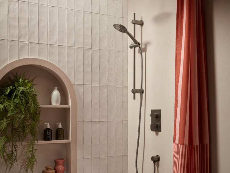 An R2 Fuse concealed dual function shower system in gunmetal with a rain head and an arched display niche