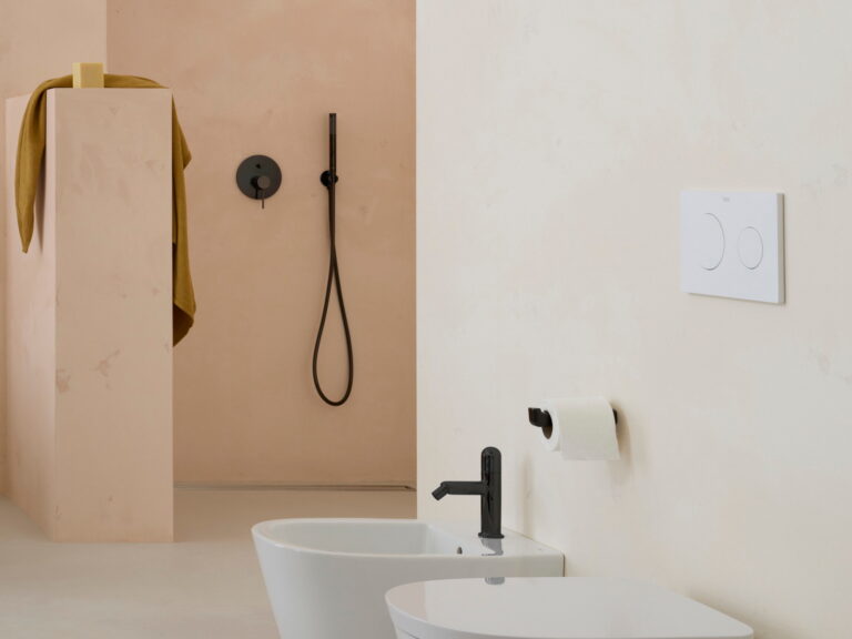 Roca wall-hung WC and bidet with matt black fittings and a concealed cistern flush plate in a plaster bathroom