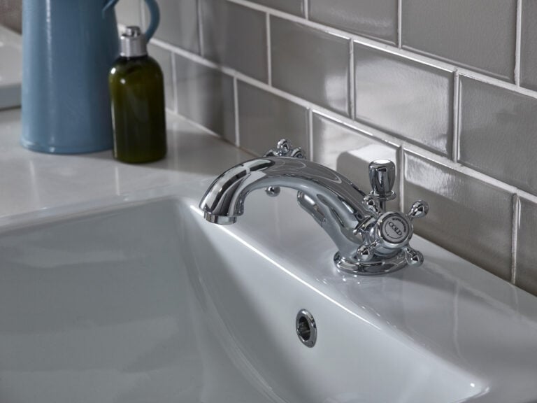 A Roper Rhodes Henley traditional crosshead basin mixer in chrome on a white basin against grey metro tiles