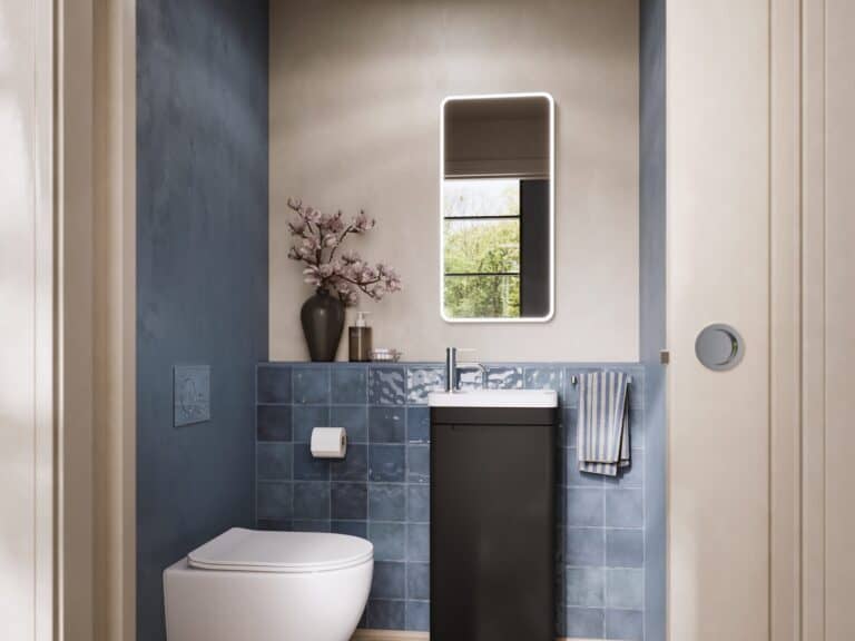 Compact basin unit and wall-hung toilet in a blue-tiled cloakroom