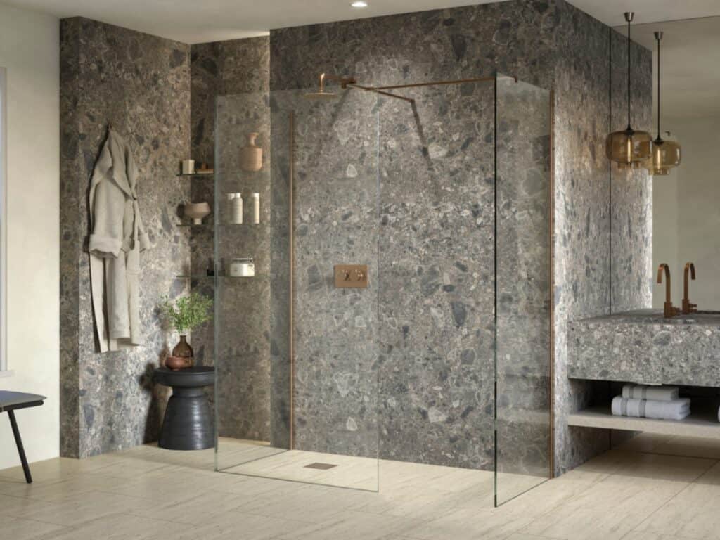 Walk-in shower with bronze-framed glass panels and stone-effect walls