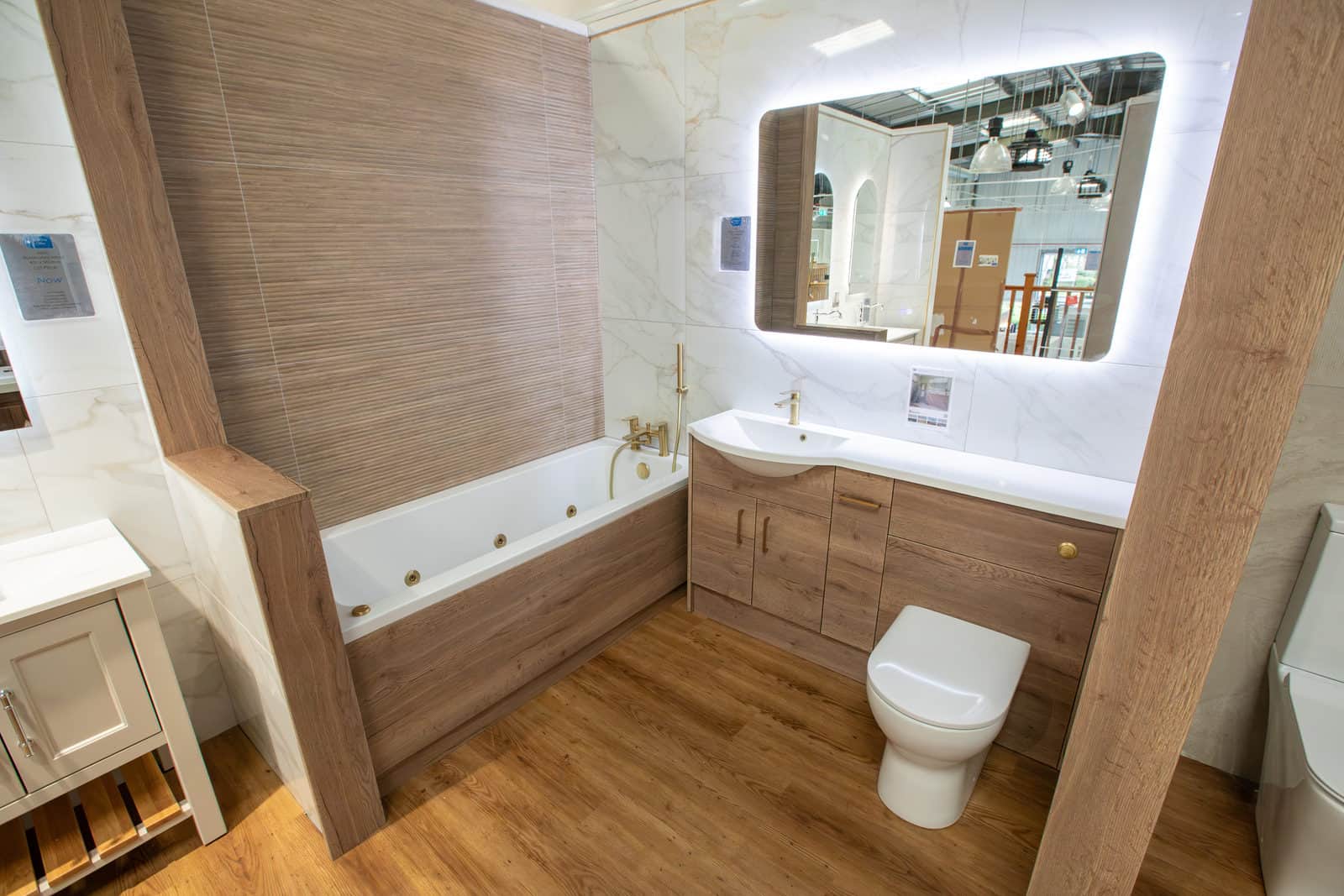A wood fitted run with a bath, WC and a long illuminated mirror