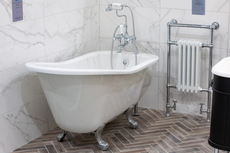 A roll top bath on chrome feet with a traditional tap and a column radiator