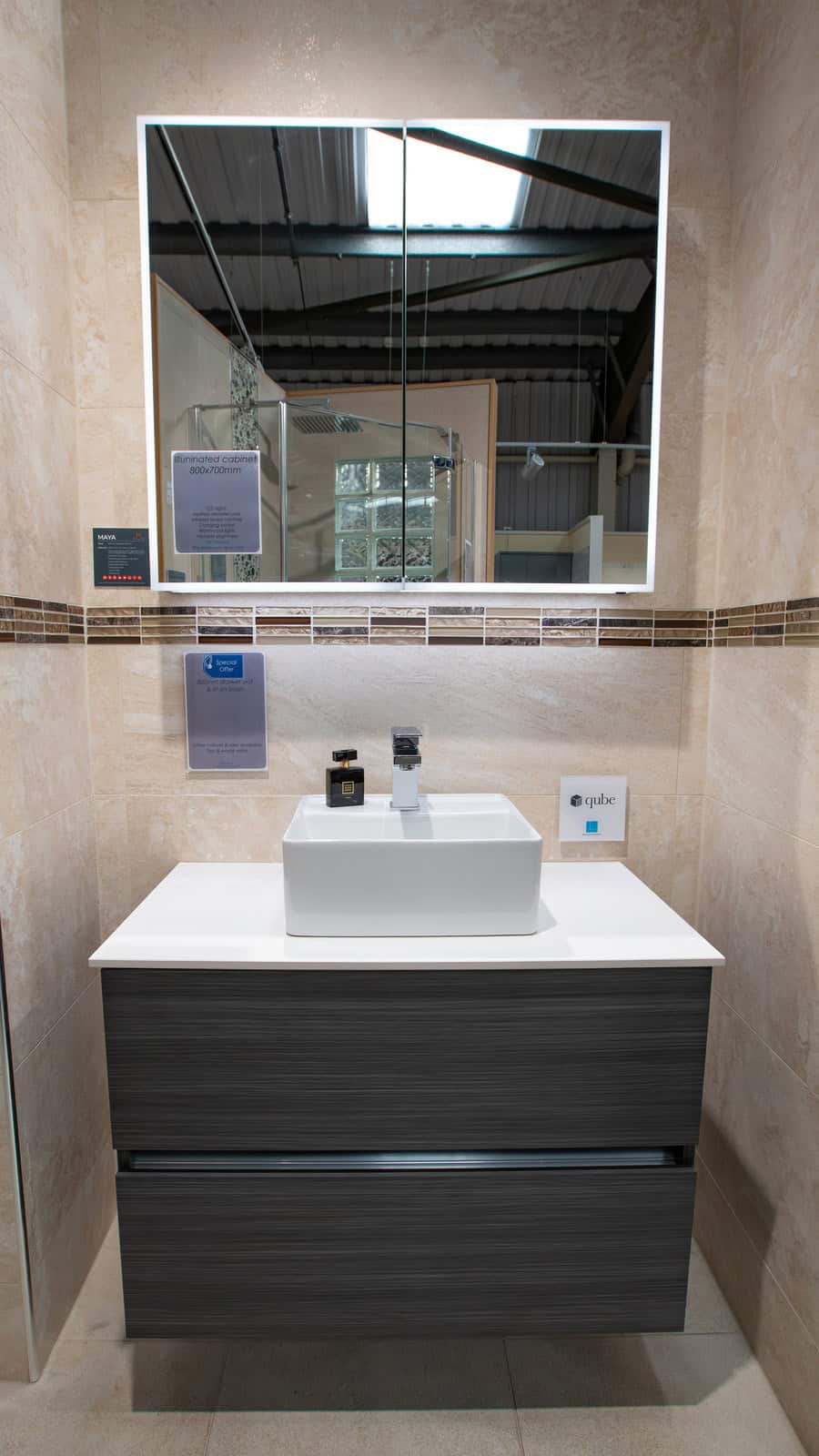 A dark wood vanity unit with a countertop basin below a large mirror
