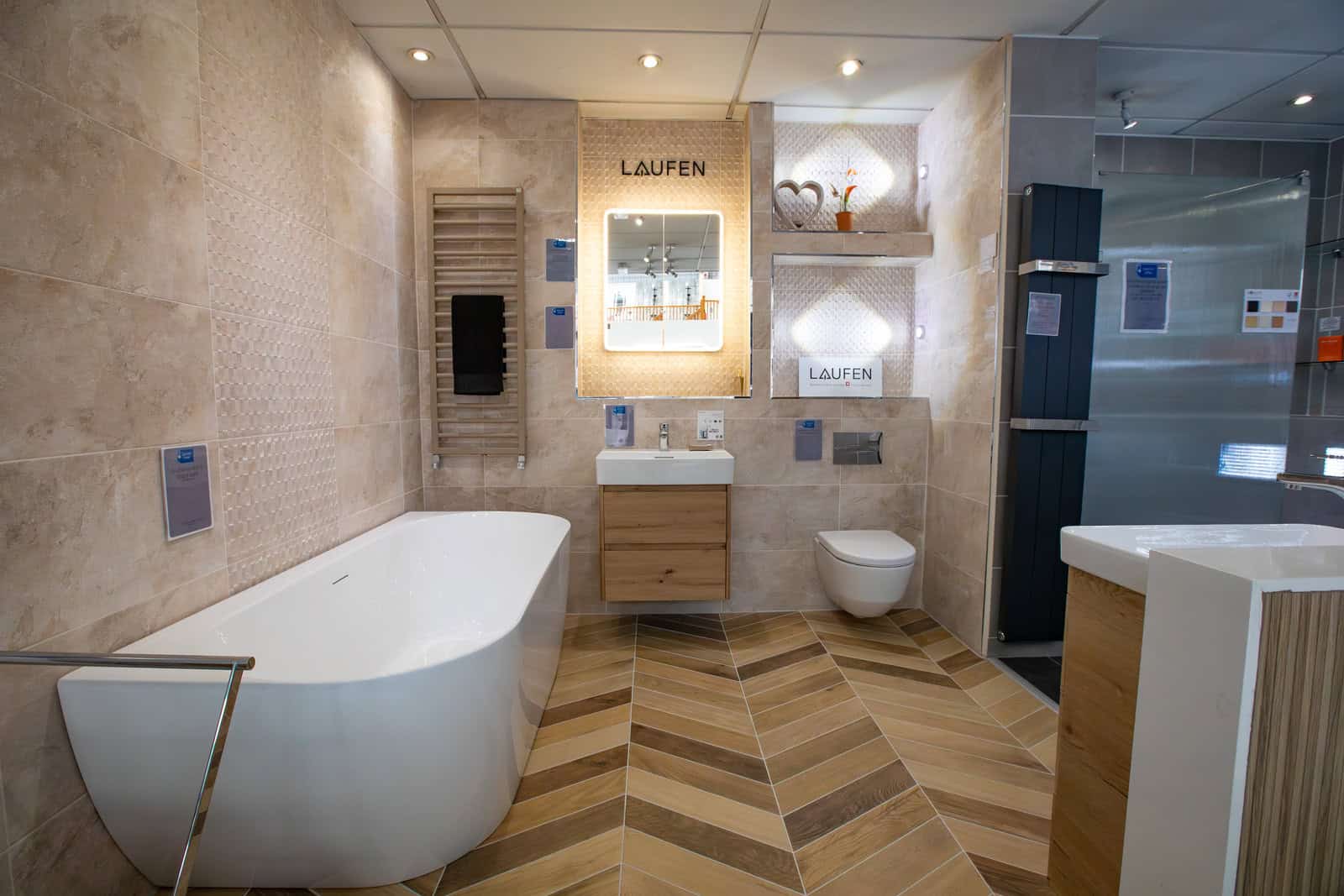 A Laufen display bay with a freestanding bath and a herringbone floor